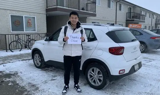 Wei L. holding a Thank You Chloe sign
